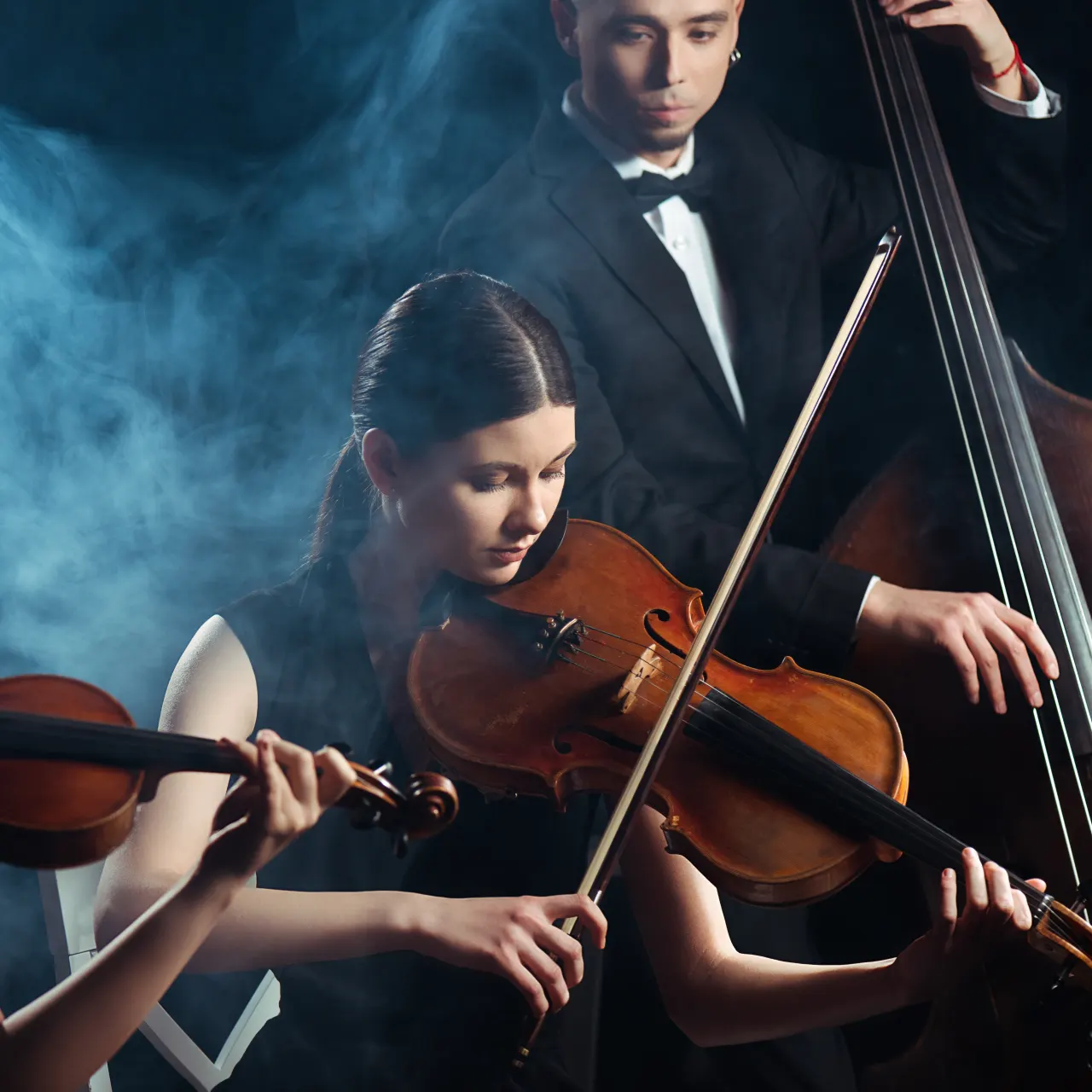 Jóvenes músicos interpretando violín, viola y contrabajo